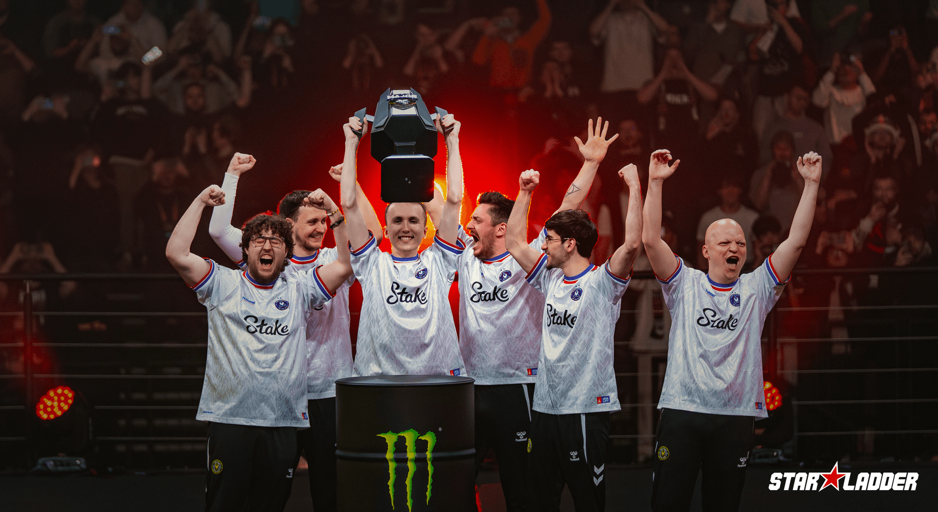 Esports team celebrating with a trophy on stage
